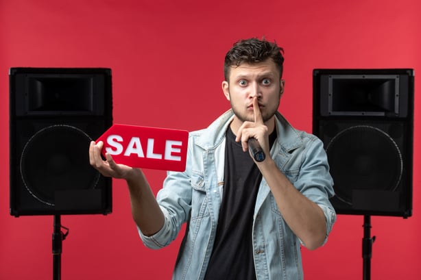 front-view-male-singer-performing-stage-holding-sale-writing-red-wall